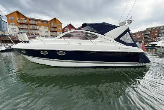 A white and navy motor cruiser moored in a marina